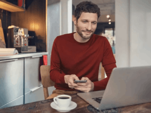 Vodafone Mann sitzt am Laptop in der Küche